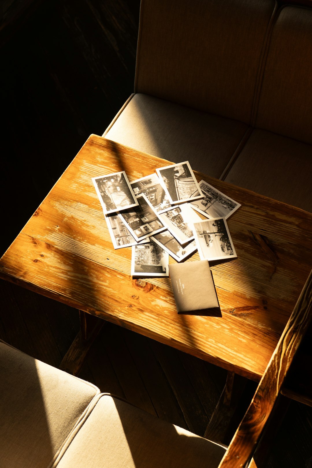 Old printed photographs and negatives on a wooden table